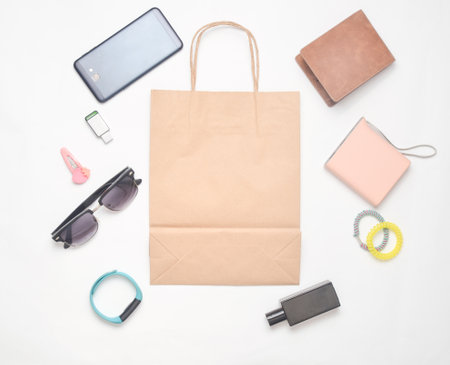 Paper bags and many purchases of gadgets and accessories on a white background: sunglasses,...