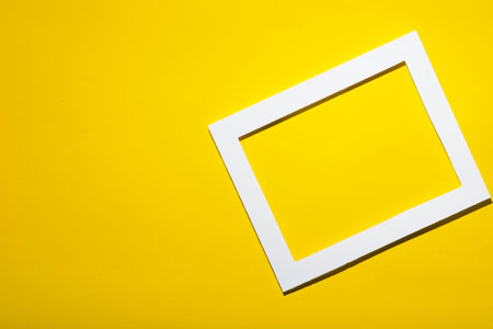 Empty frame on yellow pastel wall with copy space. Minimal concept.の写真素材