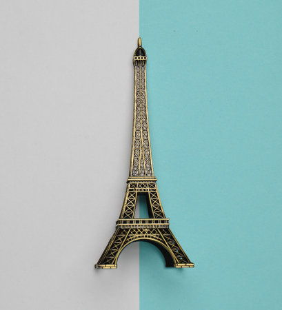 A souvenir statuette of the Eiffel Tower on a white blue pastel background. Top view. Minimalist trend.の写真素材