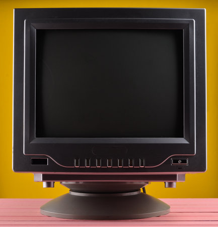 Dark lighting of a retro TV set on a yellow pastel background