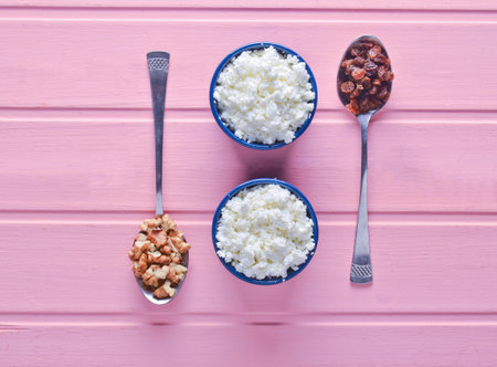 Healthy, dietary food. Morning breakfast. Bowls with cottage cheese, spoons with walnuts and raisins...