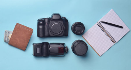 Equipment  photographer, purse with dollars, notebook on a blue pastel background. Freelance...