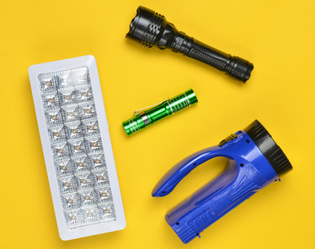 Lots of flashlights on a yellow background, top viewの写真素材