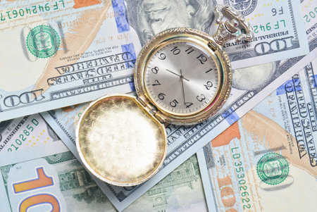 Antique pocket watch on the background of dollar bills. Time is money