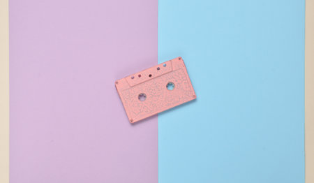 Audio cassette on a colored paper background. Retro media technology 80s. Music, entertainment. Top...