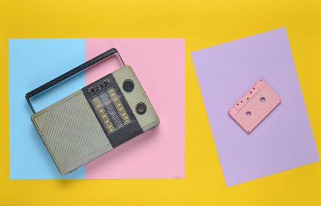 Retro radio receiver, audio cassette on a colored paper background. Minimalism. Top Viewの写真素材