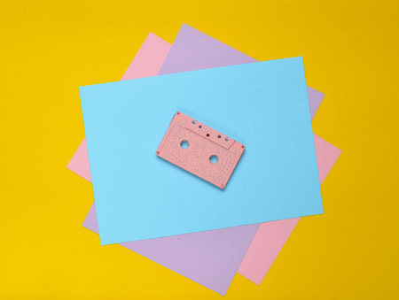 Audio cassette on a pastel-colored paper background. Retro media technology 80s. Music,...