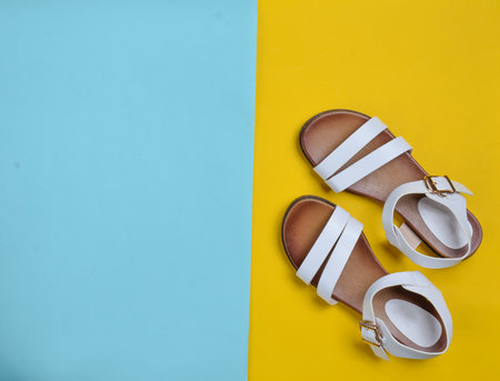 Fashionable leather women's sandals on a colored pastel background, summer shoes, top view, minimalismの写真素材