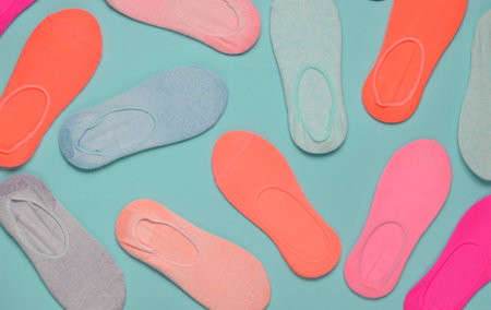 Many colored socks on a blue pastel background. Minimalism. Top View