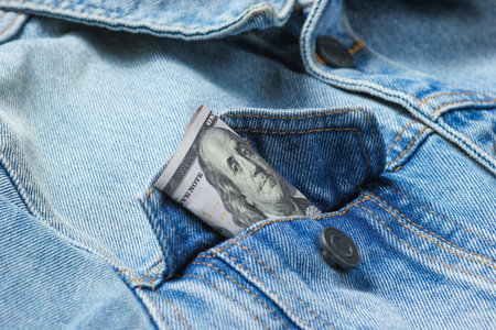 Hundred-dollar bill in your jeans jacket pocket close-up, macro photoの写真素材