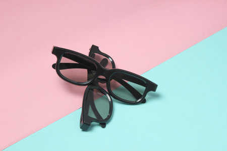 Two pairs of 3d glasses on a pink blue pastel background. Top view. Minimalism