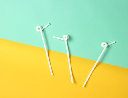 White cocktail tubes on a blue-yellow pastel background, top view, minimalismの写真素材