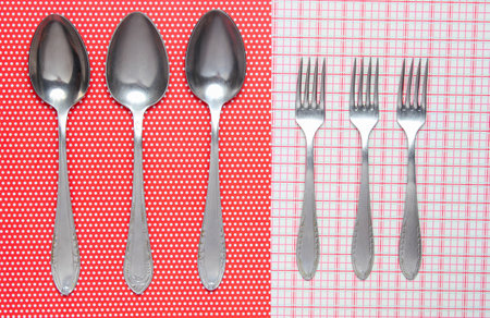 Three metal spoons and forks on a tableclothの写真素材
