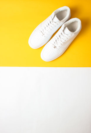 Fashionable white sneakers on a colored pastel background, minimalism, top view, creative layoutの写真素材