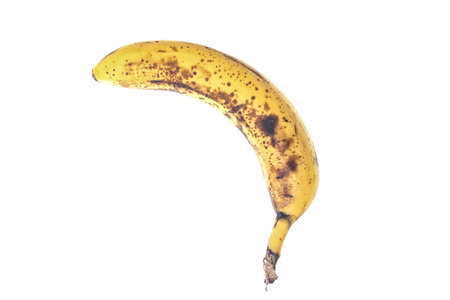 Rotten banana with black spots isolated on white backgroundの写真素材