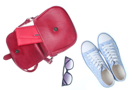 Fashionable women bag, purse, sneakers, sunglasses isolated on white background. Shoes and accessories. Top view.の写真素材
