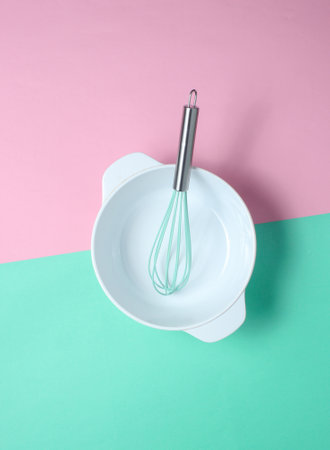 White empty bowl with a whisk on a pastel colored background. Top view, minimalismの写真素材