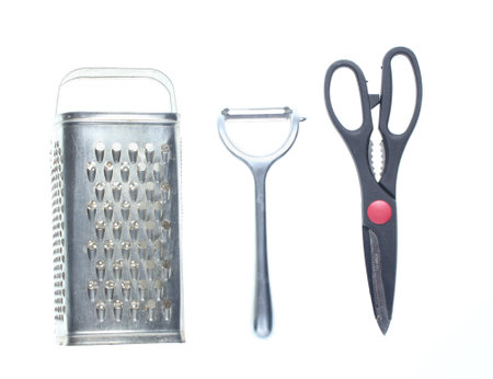 Grater, knife for cleaning potatoes, scissors isolated on white background.