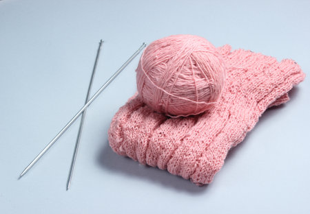 Knitting needles, thread balls, yarn on a gray background.