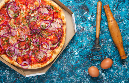 Home made pizza, eggs, corolla on a blue rustic background. The process of cooking pizza. Top viewの写真素材