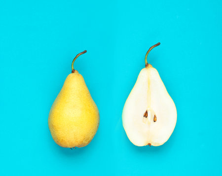 Ripe sliced pear on a blue background. Minimalismの写真素材
