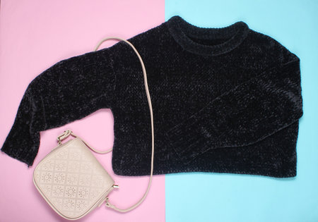 Black sweater, leather bag, on a pink background, minimalism, top viewの写真素材
