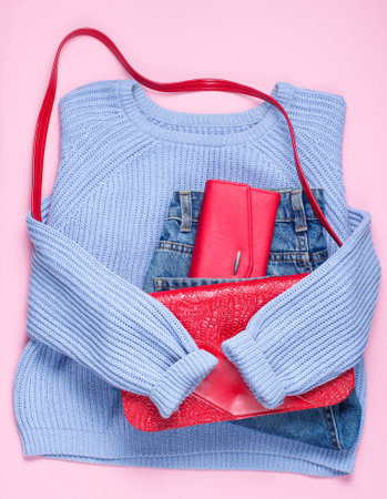Flat lay style fashion clothes on pink background. Women's sweater, jeans, retro bag, red wallet. Top view. Fashion lookの写真素材