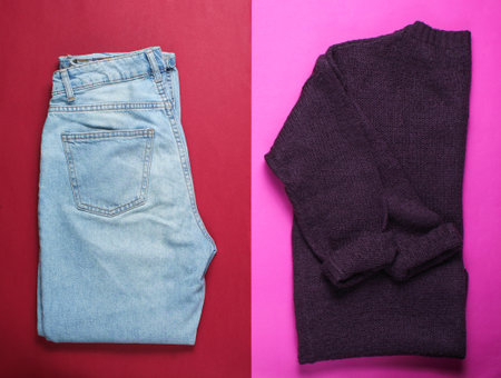 Flat lay style burgundy knitted sweater, trendy blue jeans on red pink background, top view, minimalismの写真素材