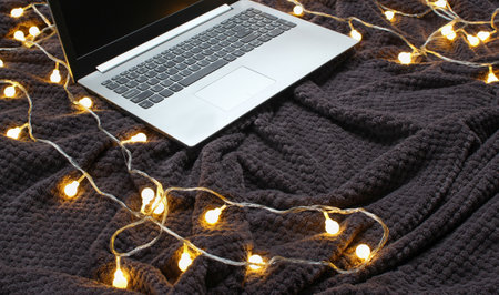 Laptop on a gray bedspread with garlands. Christmas moodの写真素材
