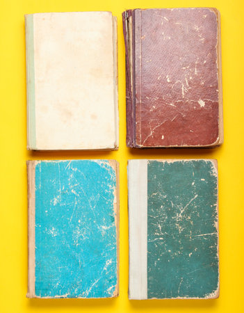 Many old book with shabby cover on a yellow backgroundの写真素材