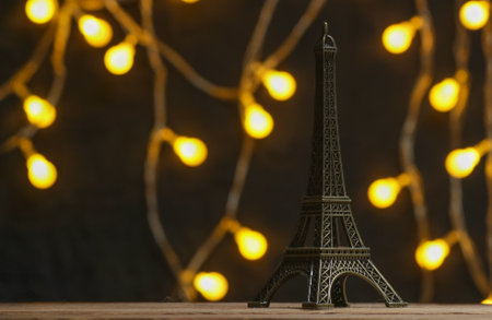 Bronze Statuette of eiffel tower on dark background with garlands.の写真素材