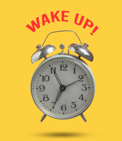 Wake up! Old retro style alarm clock isolated on yellow background. 6:55 am. minimalism. Photo with...