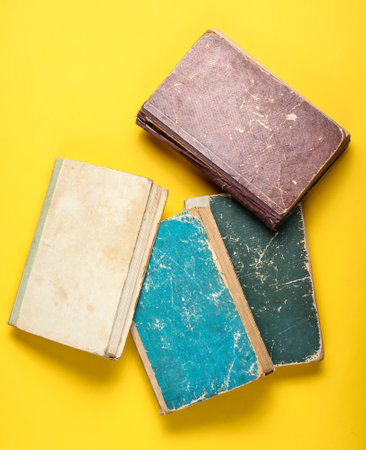Many old book with shabby cover on a yellow backgroundの写真素材