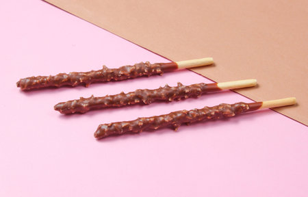 Chocolate sticks on brown-pink paper background.Â の写真素材