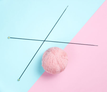Knitting needles, skeins of wool on a pink-blue pastel background. Top view. Minimalism
Â の写真素材