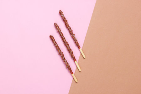 Chocolate sticks on brown-pink paper background. Top View, minimalism
Â の写真素材