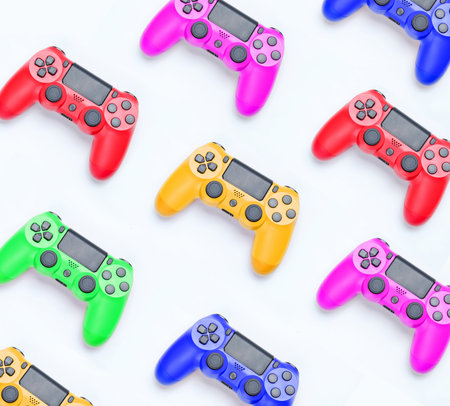 Many colored plastic gamepads on a gray background. Concept individuality. Creative background. Top...