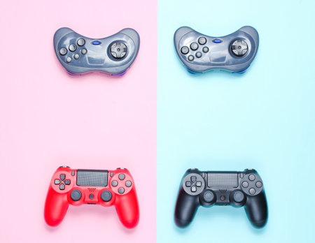 Modern and retro gamepads on a pastel blue-pink background. 80s entertainment. Top view, minimalismの写真素材