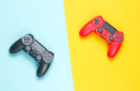 Two gamepad on a colored paper background. Video game. Minimalism, top view.