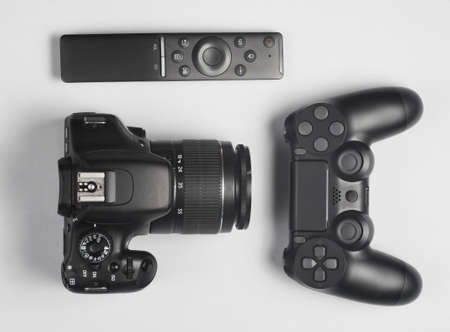 Gamepad, Dslr camera, tv remote. Modern gadgets and devices on gray background.  Top view.