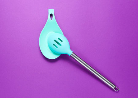 Silicone spatula for cooking with a metal handle on a stand on a purple background. Minimalismの写真素材