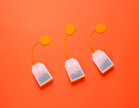 Three silicone tea bags on orange background. Top view, minimalismの写真素材