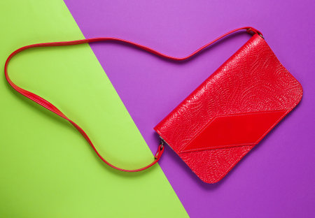 Retro style red leather bag on purple green background. Top viewの写真素材