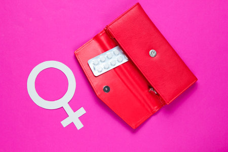 Women Health. Female gender symbol, pills in red purse on pink background.の写真素材