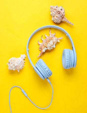 Beach music. Headphones, sunglasses, shells on yellow background. Top view.の写真素材