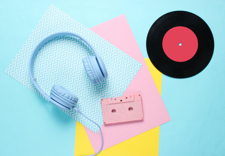 Headphones and earphones with audio cassettes on colored paper backgrounds. Retro style, minimalism. Flat lay. Top view.の写真素材