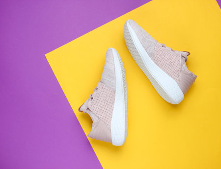 Sneakers. Sports shoes on a creative purple yellow paper background. Overhead shot of running shoes.Top viewの写真素材