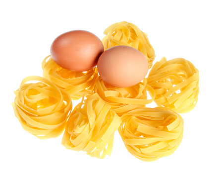 Raw dry tagliatelle noodle, eggs close up isolated on white backgroundの写真素材