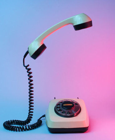 Old style rotary telephone with soaring telephone handle, blue red neon light, 80s