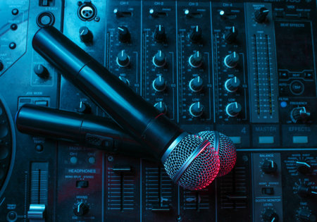 Night club, nightlife concept. Disco. Two microphone on DJ remote. Neon red blue lightの写真素材